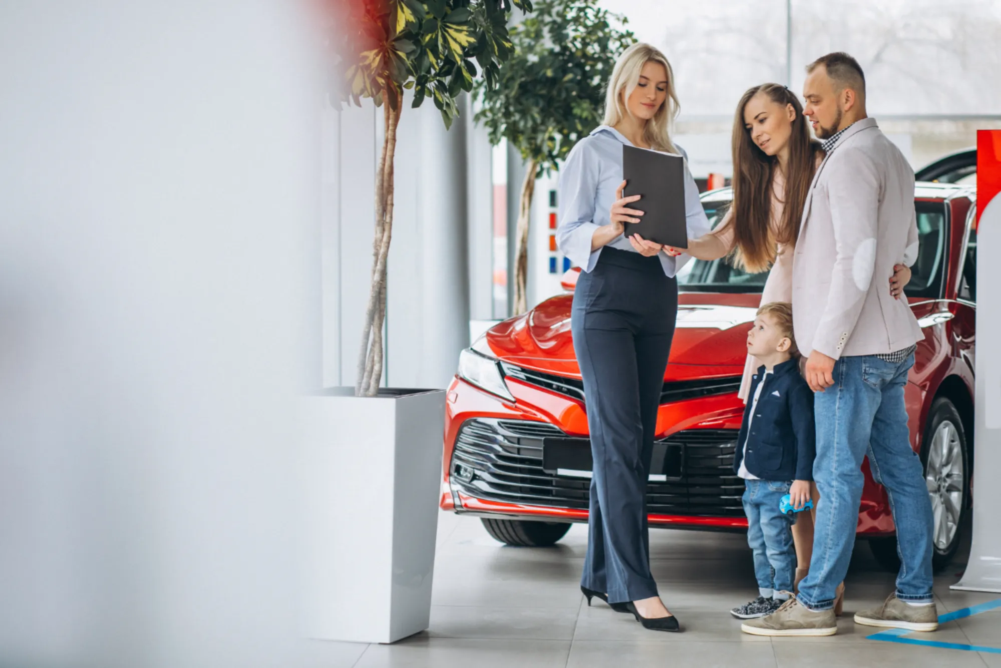 Family reviewing a new vehicle at a dealership representing future car trends in Canada with Value Car Deals