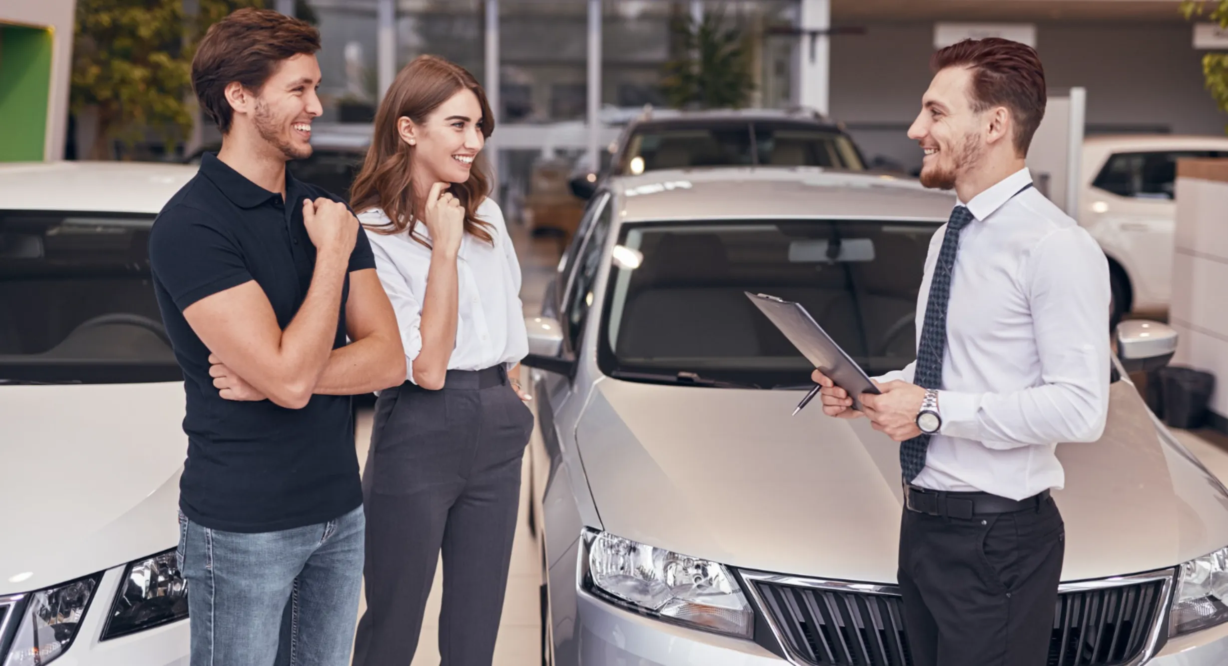 Car buyers speaking with an advisor about vehicle insurance coverage in Canada with guidance from Value Car Deals