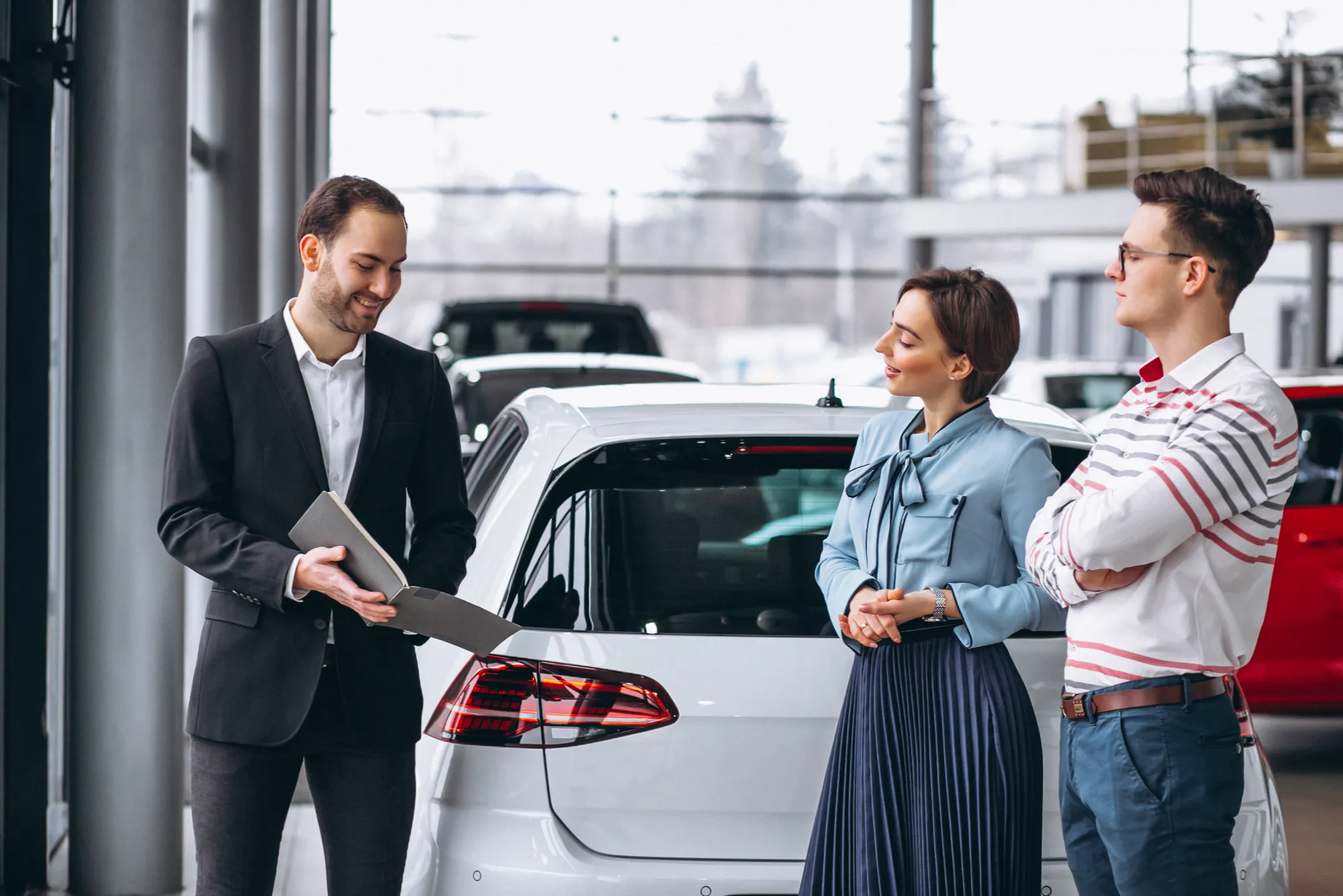 Customers discussing car financing options with a dealership advisor in Canada at Value Car Deals